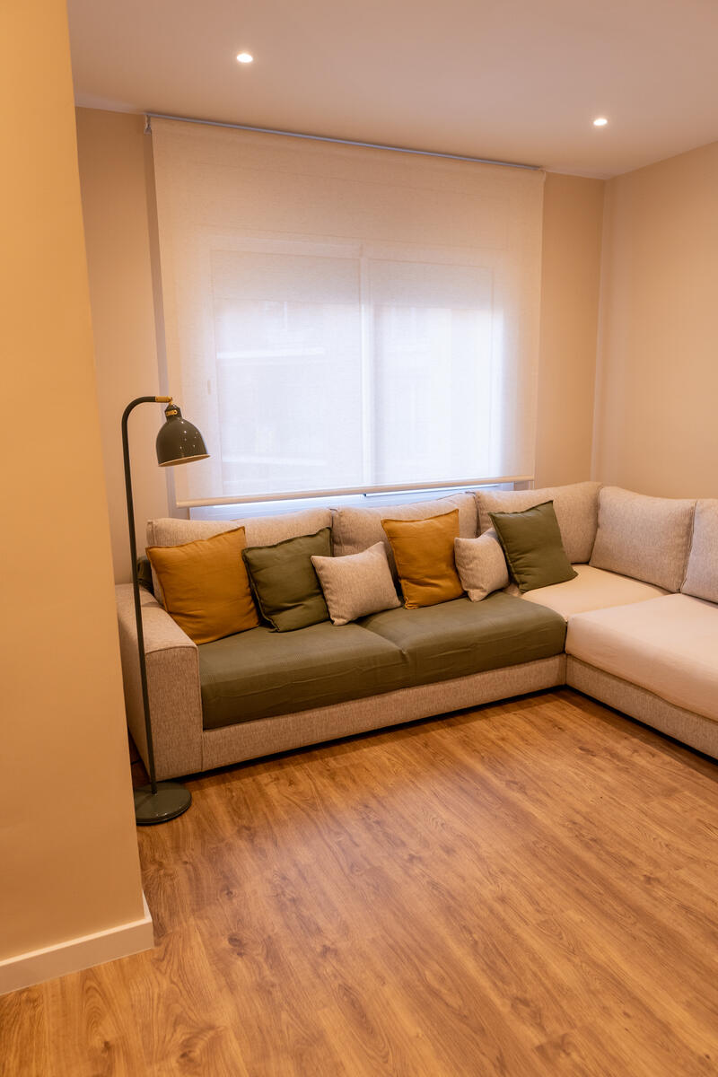 Salón con sofá esquinero y suelo de madera