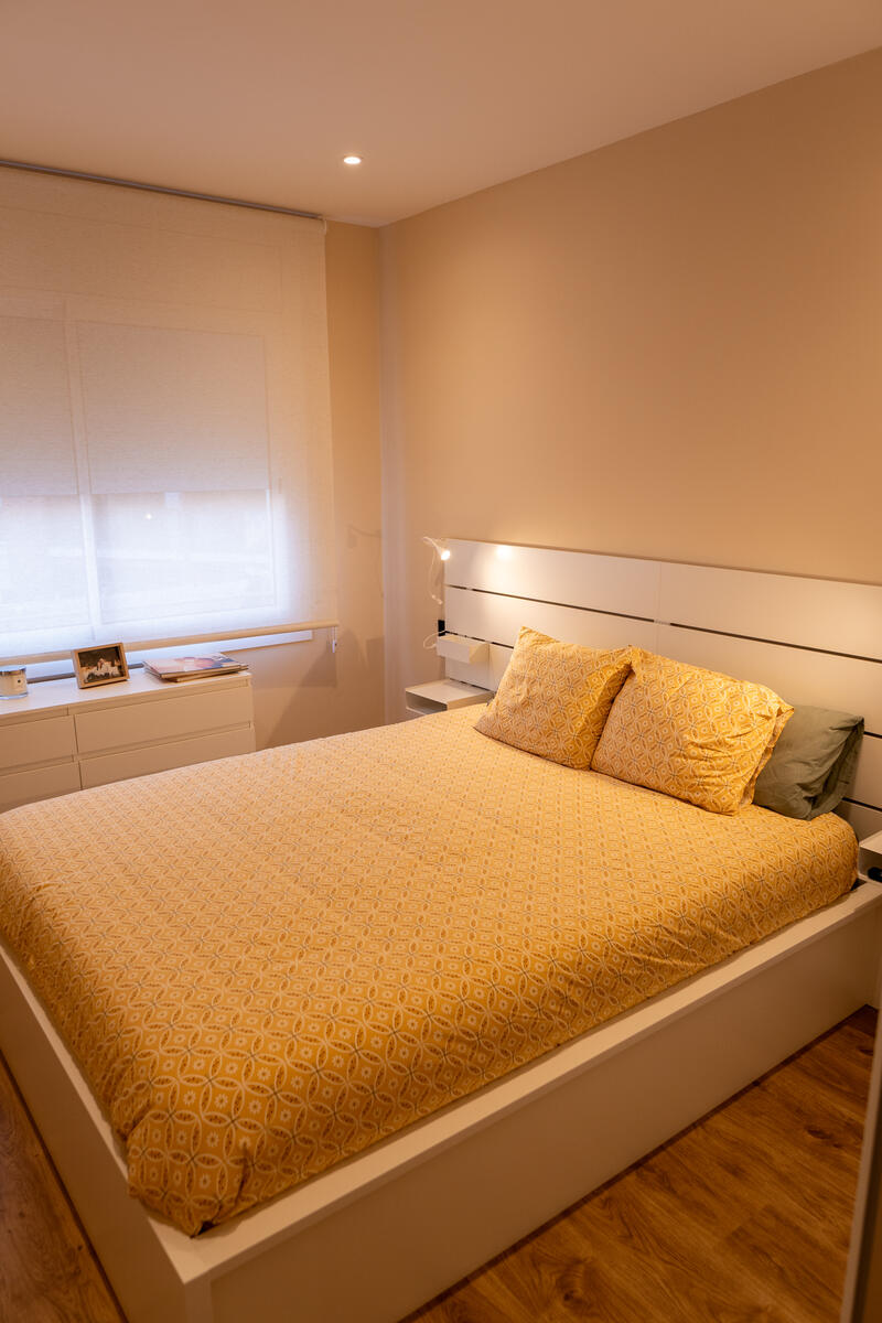 Dormitorio con cama doble y mesita