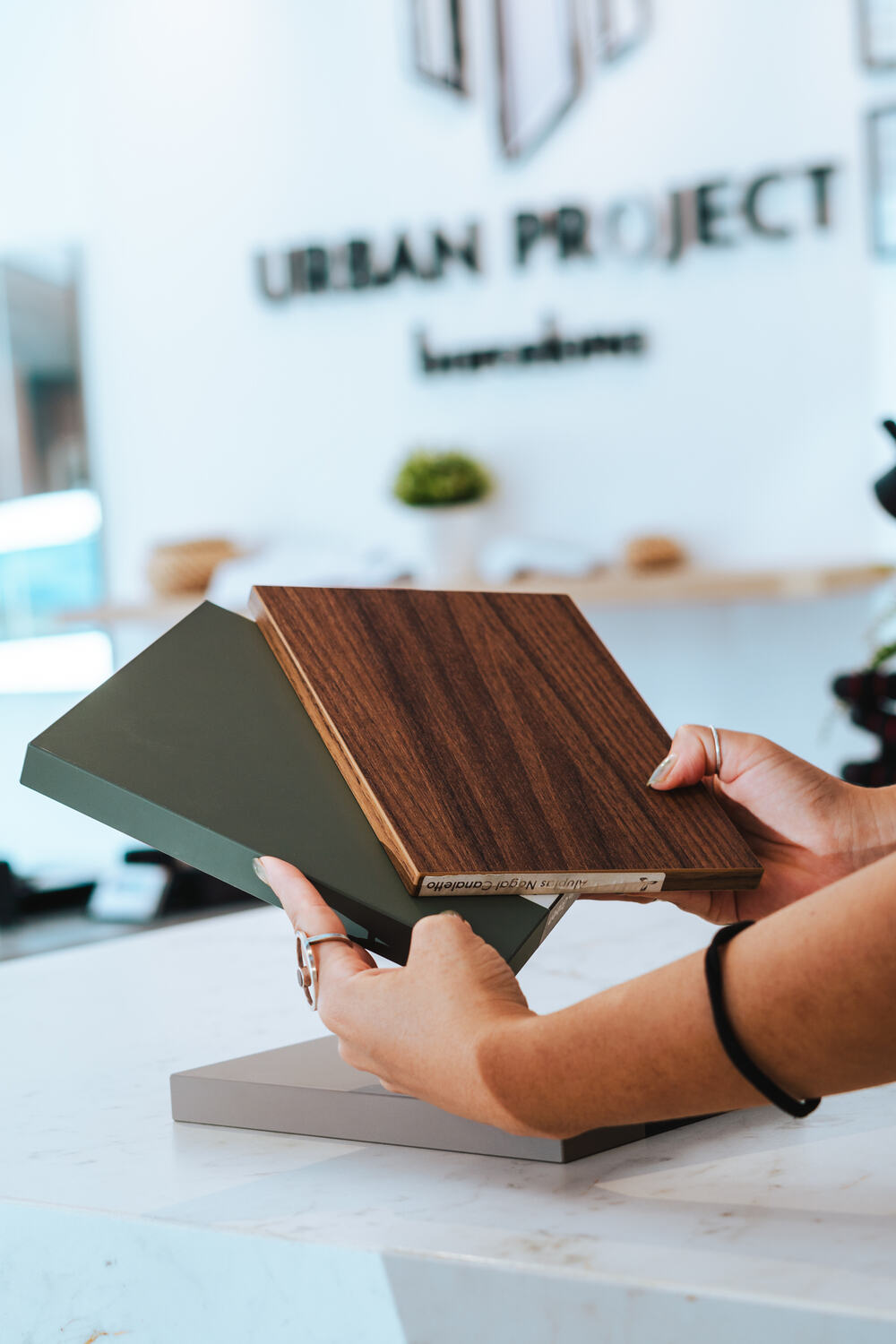 Muestras de materiales y madera frente al logotipo de Urban Project